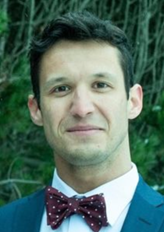 A person in a suit and bow tie

Description automatically generated